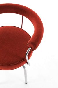 Siège Pivotant，由Charlotte Perriand于1927年设计:一把红色软垫的椅子，配有细长的金属扶手和腿