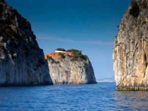 Villa Malaparte, as seen from the sea, perched atop a greened cliff.