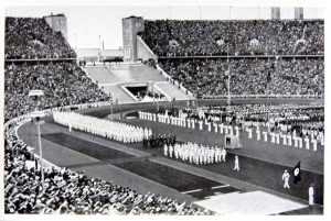 German Olympic Team Marching in the Olympic Stadium in Berlin (1936): Black and white photo of the statium.