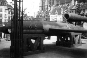 a V-1 on display on the Groenplaats, Antwerp (in the backgound Antwerp Cathedral): Black and white photo of the aircraft.