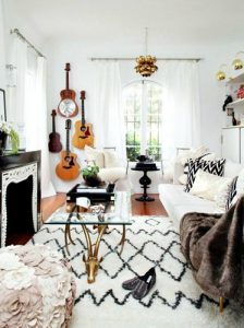 波西米亚风格的室内黄铜奢华混合照片，纹理地毯，枕头和毯子，墙上的吉他和黑白对比。