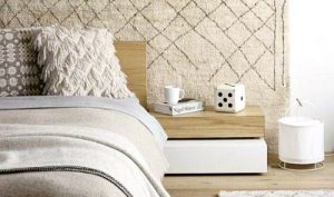 波西米亚风格的室内装潢:白色的波西米亚风格的房间，带有对比鲜明的纹理，有一张床和一张边桌。