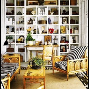 波西米亚室内照片，拼贴式书柜和带有黑白条纹枕头的呜呼椅